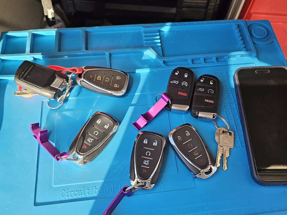 Smart key fobs for several makes laid out on the work mat inside the service van in Milwaukee
